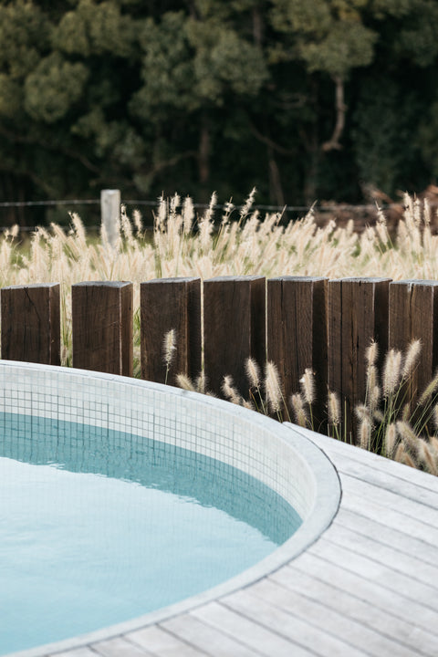 Pool area with wooden fence and ornamental grasses