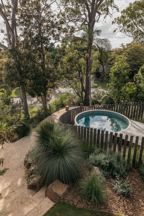 Private plunge pool surrounded by timber fence and lush sub tropical trees and greenery